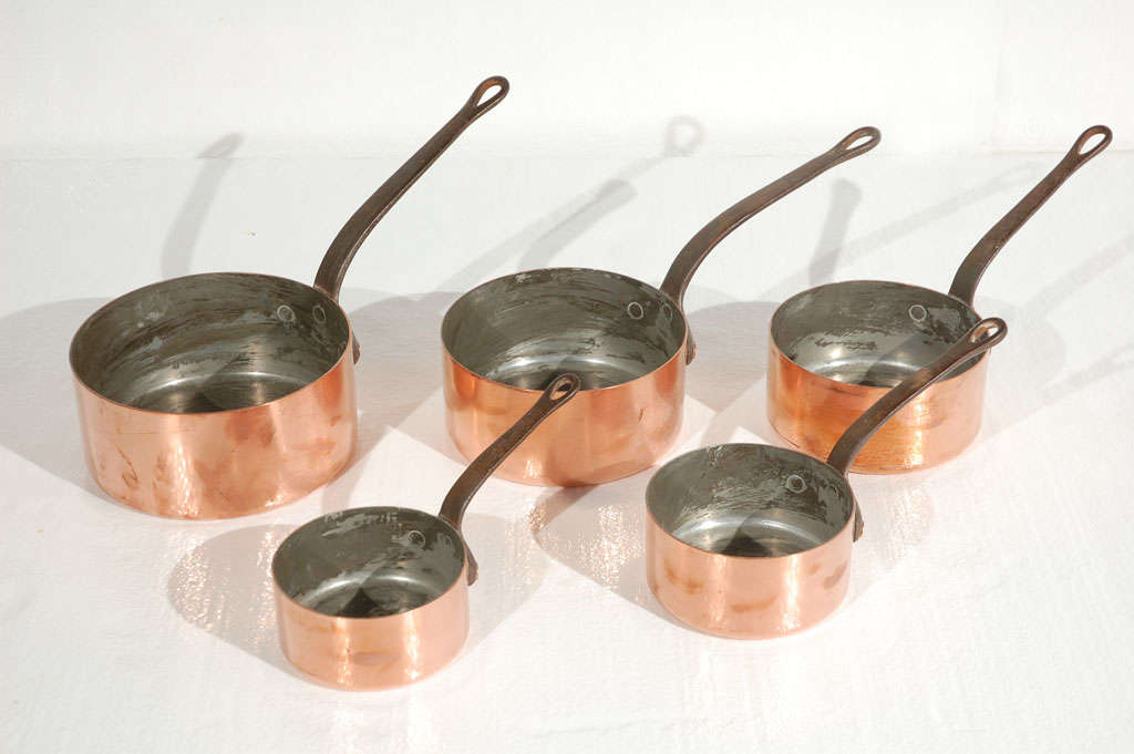 Set of 5 antique copper and tin lined pans from France. Hand forged handles and hand riveted to pans. Sold as a set. Pan sizes are 8