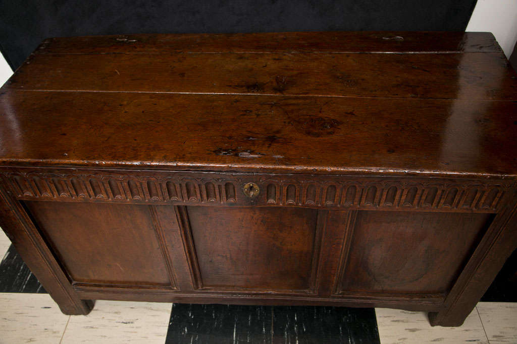 Handsomely paneled, this oak coffer features decorative carving to the front frieze and an interior candle box. Stile supports round out the Classic design and construction.