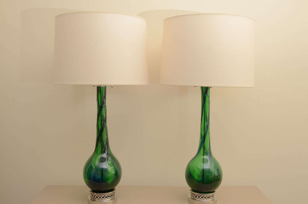 Wonderful pair of large Murano glass lamps in A beautiful Emerald green with blue swirls. the lamps are mounted on polished  Nickel bases and have been newly rewired with double clusters.