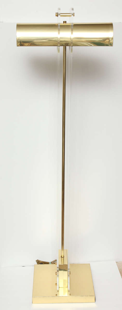 Decorative brass and Lucite, Mid-Century Modern, Italian floor lamp. Designed in Italy, circa 1960.
The floor lamp has two light bulbs under the brass shade, on each side which gives out good light.