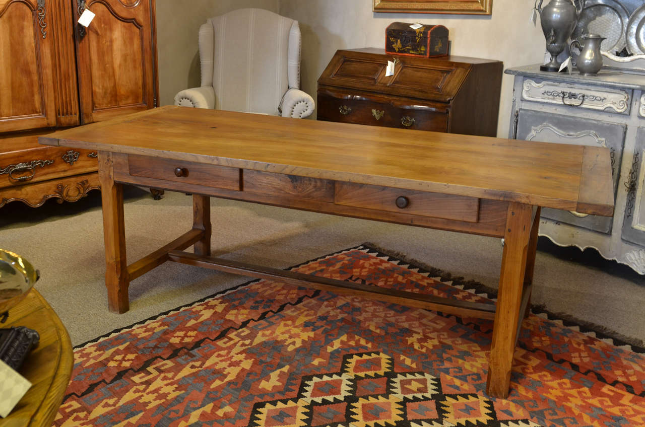 A wonderful dining table handmade in ash from the 1920's.  It has a massive presence and great details with the trestle base and chamfered legs.  The two drawers are good for storage of placemats and napkins.  The top overhangs 11