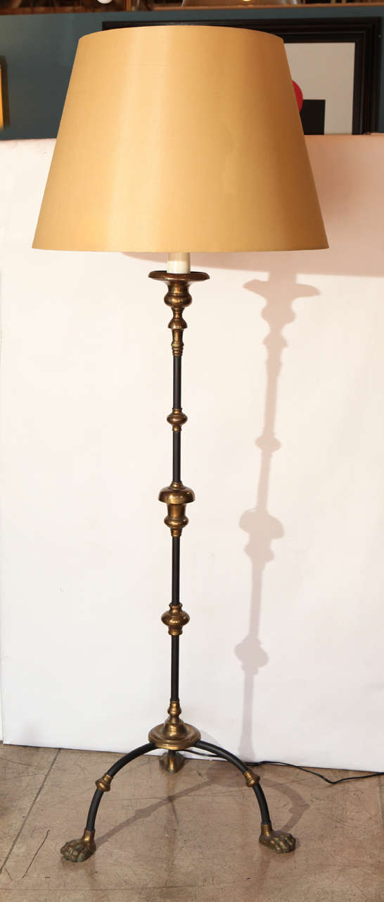 A wonderful Italian Hollywood Regency floor lamp in black enameled metal and bronze. Newly rewired with a custom silk shade. Amazing detail to the paws feet. Brass hardware. Measures: Shade is 26