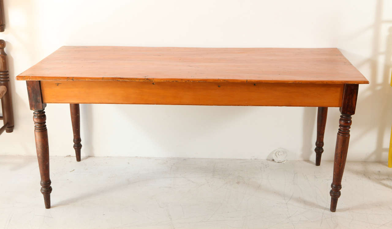 American rustic farm table with dark stained legs and light stained top and apron. Newly refinished and refurbished.