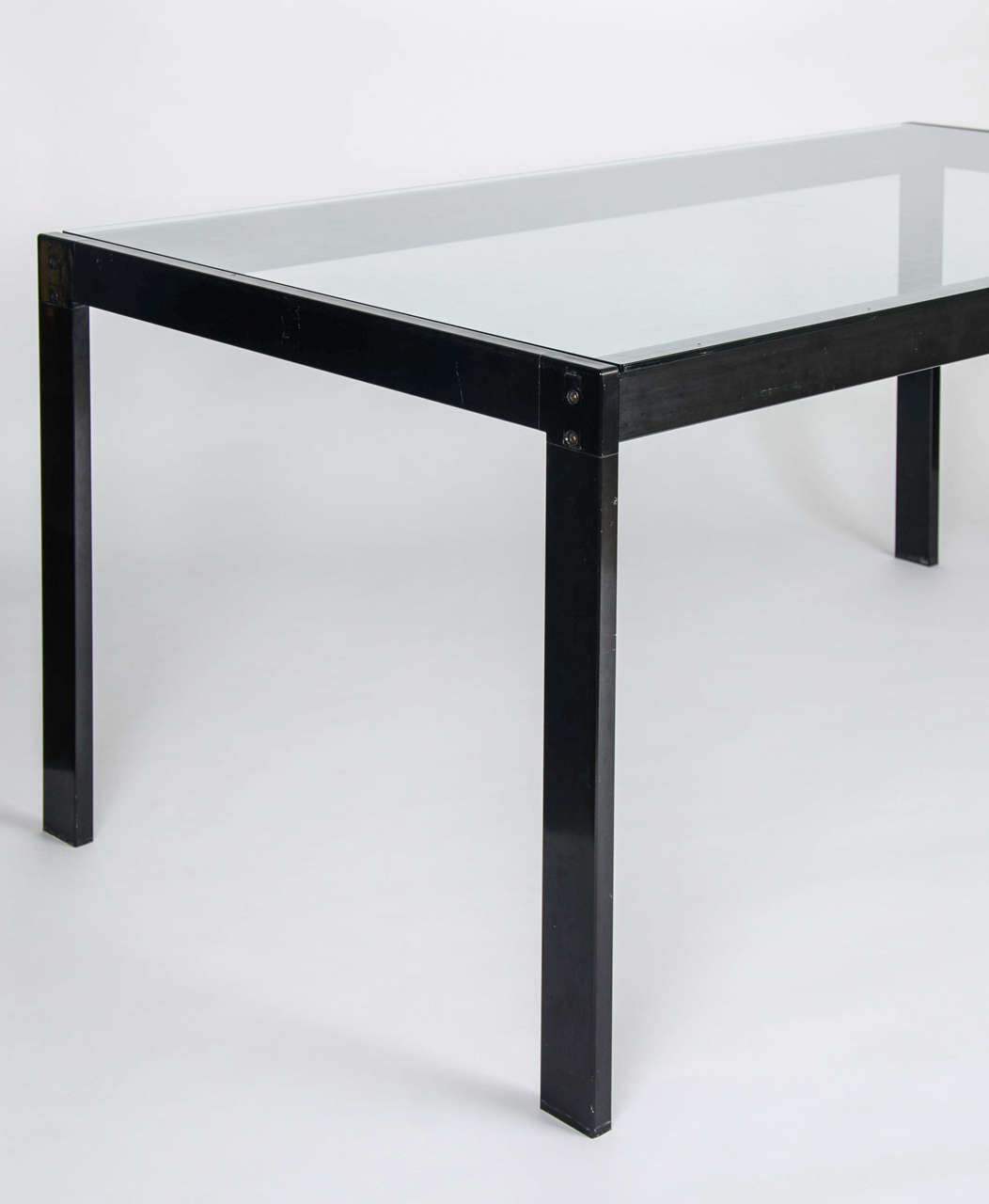 An excellent example of Knoll furniture. A smoked glass and black metal dining table.

By Florence Knoll.