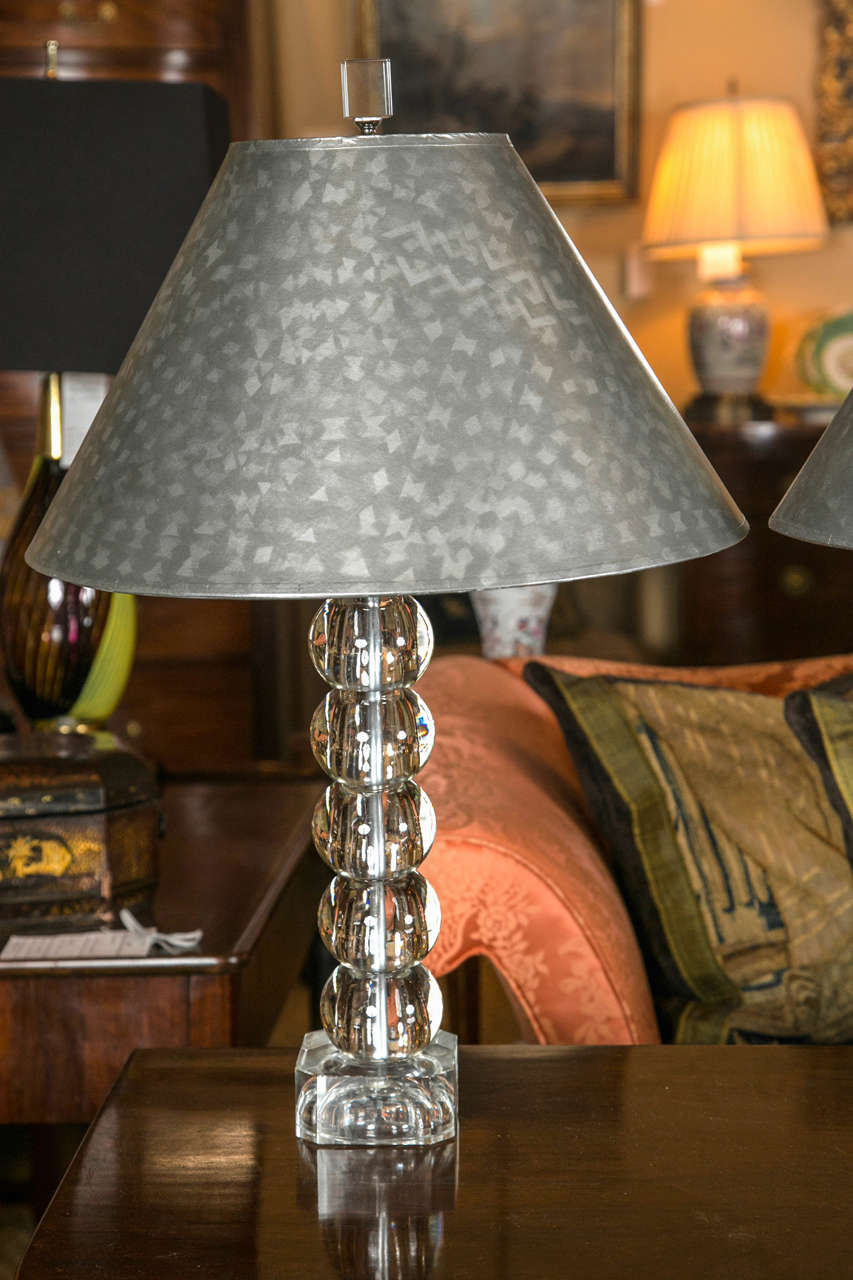 A pair of modern glass candlestick lamps with hand-painted metallic 
shades.