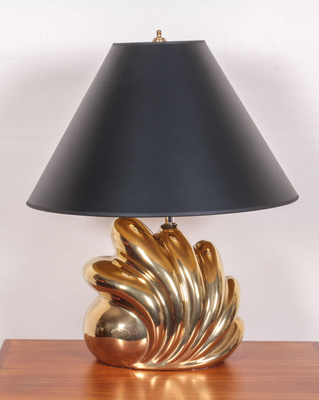 Wonderfully large-scale shell-form porcelain lamps glazed in a glamorous gold luster. Note that photo is picking up reflection of surrounding colors. Comes with black paper shades lined in gold foil.