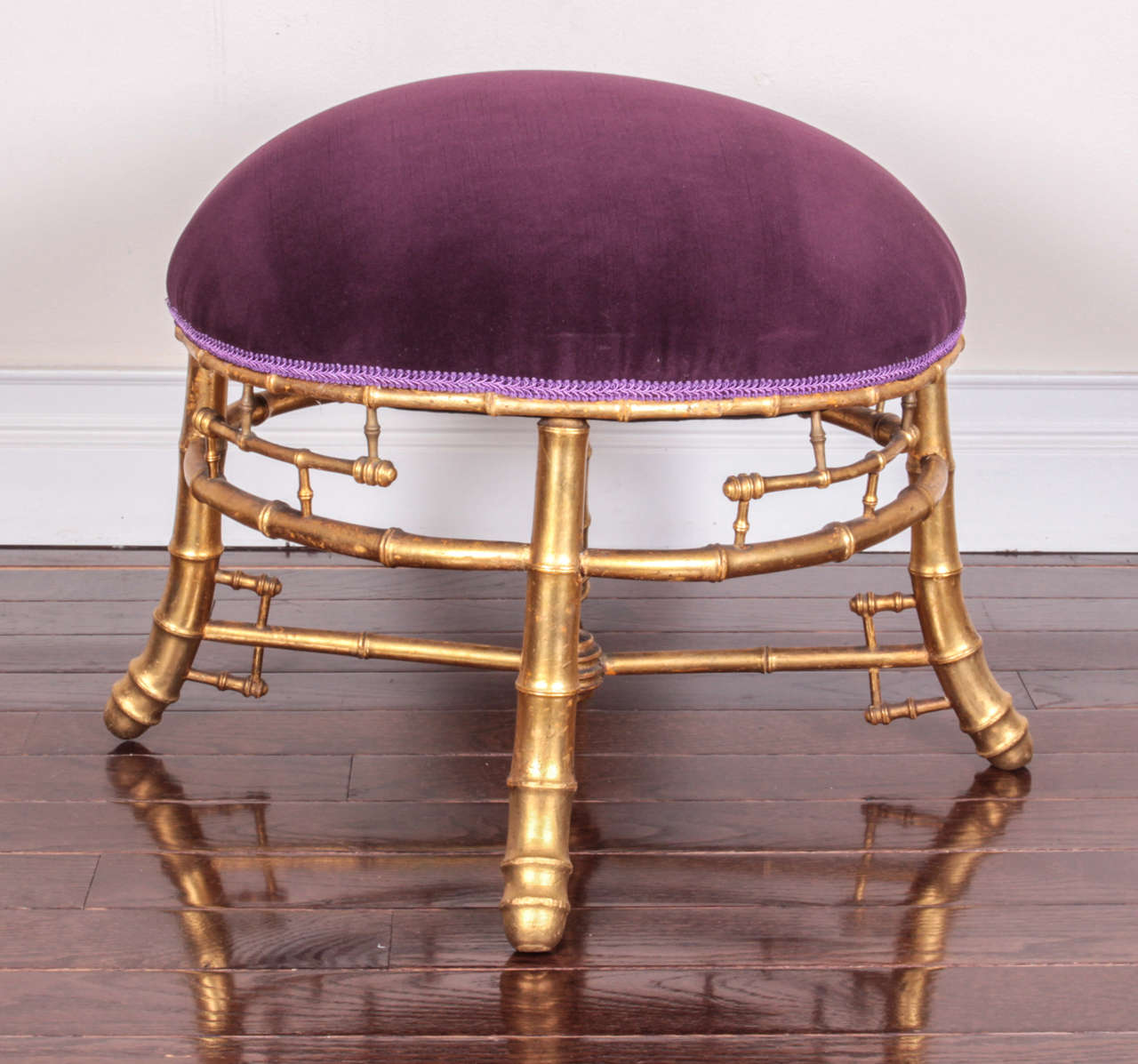 The round purple velvet upholstered seat raised on bamboo-form legs joined by an x-form stretcher with turned finial.