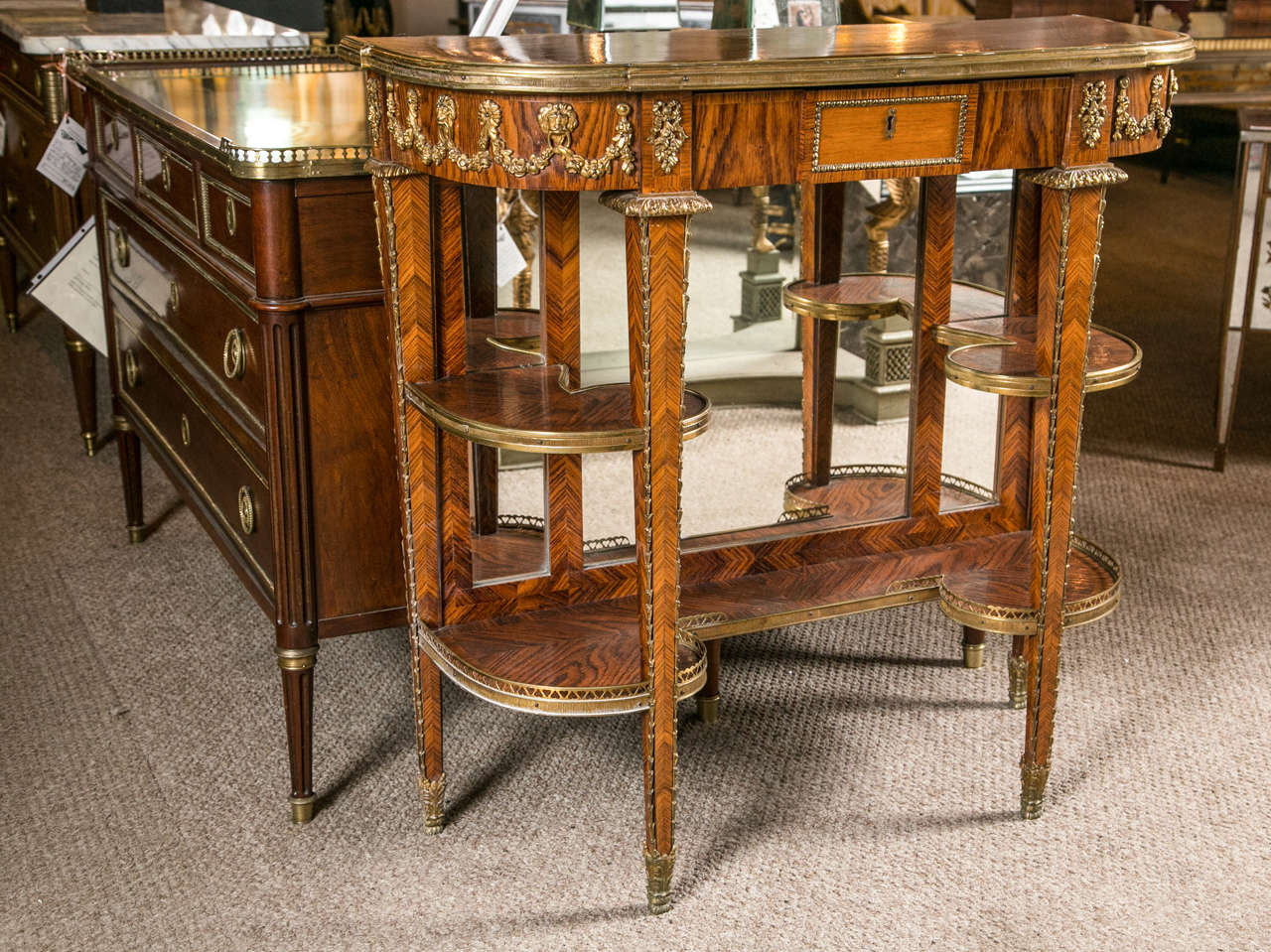 Rosewood mirrored back console table. In the style of Louis XVI, this fine piece has richly hued timbers with brownish and darker veining. Bronze-mounted dessert serving cart or console table. Attributed to Maison Jansen.