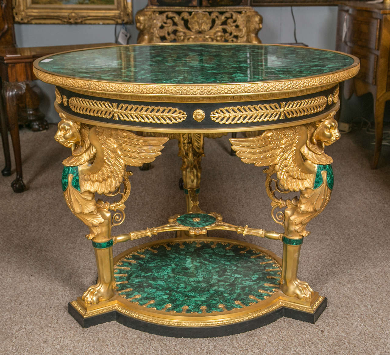 Fine doré bronze and malachite green figural center table. Russian Imperial style figural gilt bronze and malachite mounted table de Milieu, with figures of winged lions, acanthus leaf and wreaths.