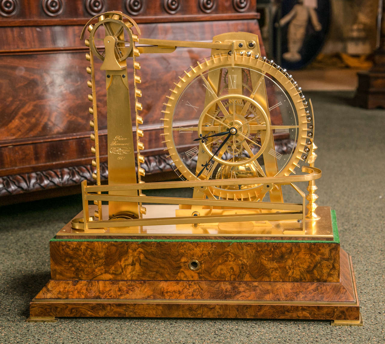 An English gilt brass constant force waterwheel timepiece by the highly respected contemporary horologist Peter Bonnert.

The six pillar movement with pierced tapered plates, three wheel train with six-spoke wheel crossings and deadbeat escapement