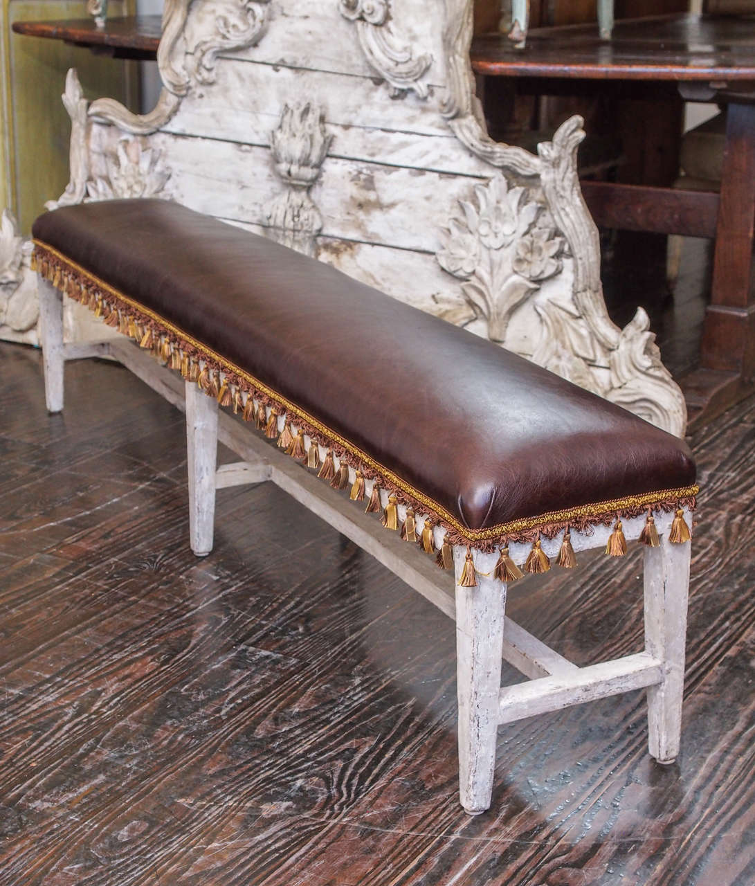 Pair of painted 18th century benches with leather and silk fringe.