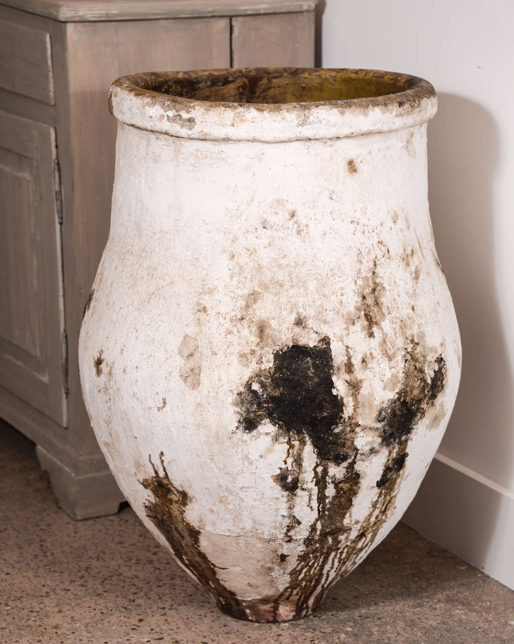 Large 19th century tapered-shape terracotta olive jar (pithari) with a beautiful white patina and remnants of yellow glaze along the rim and inside the jar.