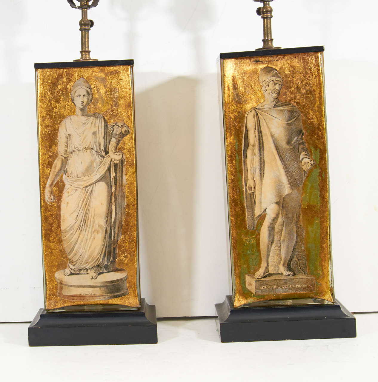 A pair of vintage table lamps attributed to Piero Fornasetti. They have glass bodies with Greco-Roman neoclassical motifs in eglomise and sit on ebonized wood bases.

Reduced from: $5,500