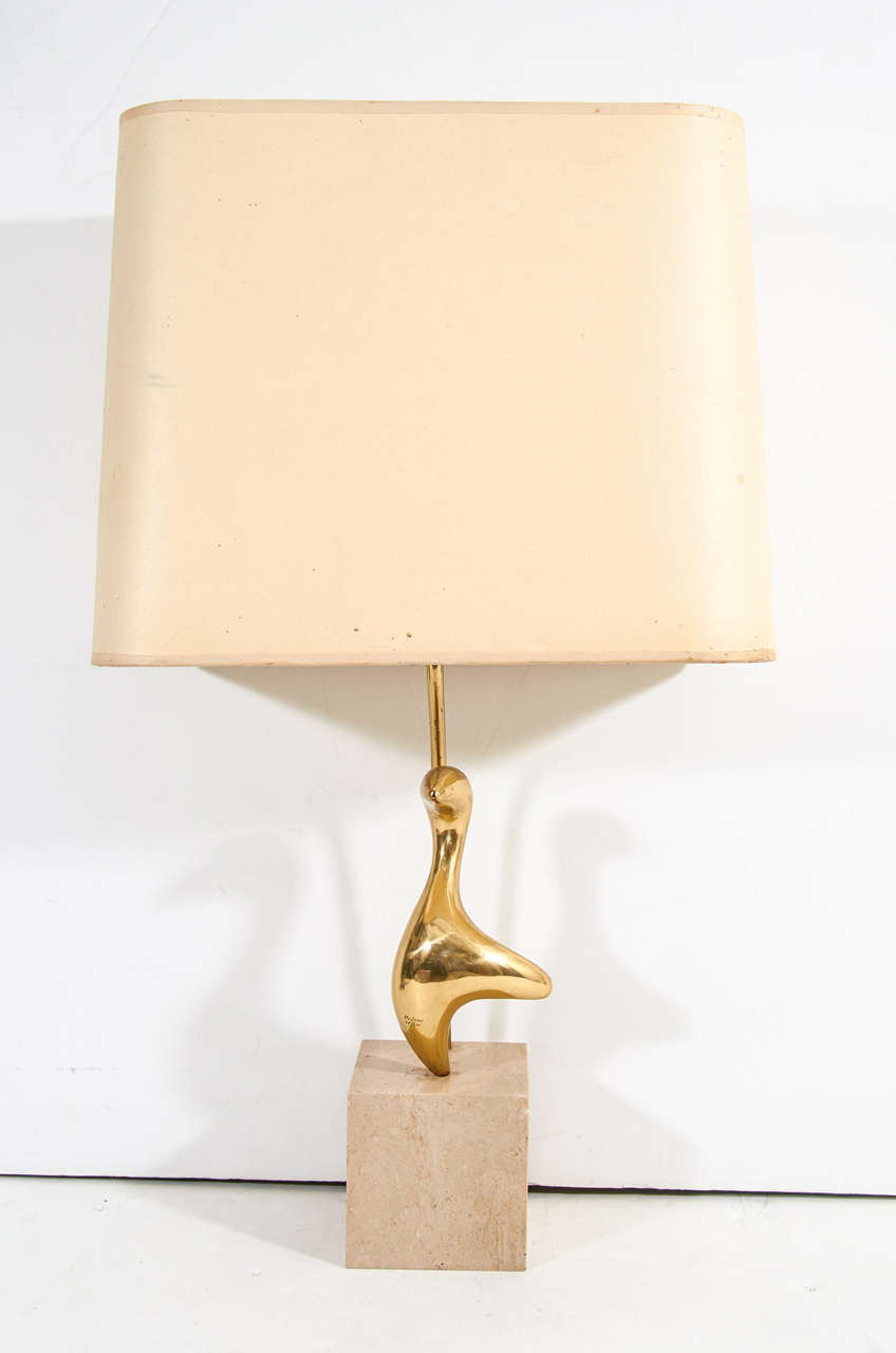 A vintage petite table lamp with a marble block base supporting a  brass, abstract sculpture signed and numbered by Philippe Jean. European wiring and socket

Reduced from: $1,150