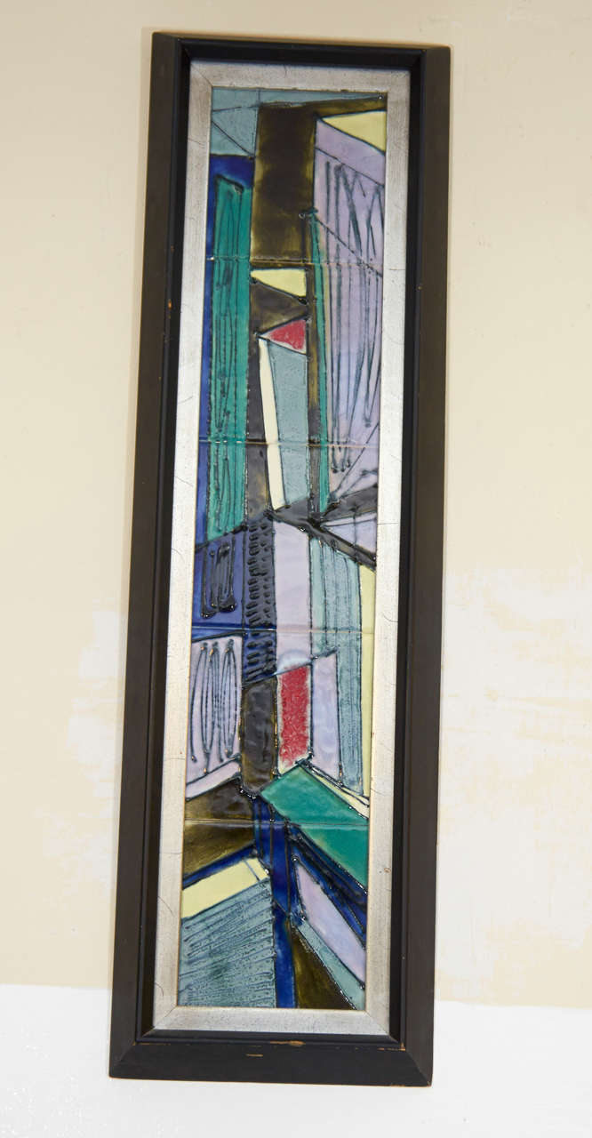 A pair of vintage wall mounted tiles by Harris Strong in blue green and yellow with wood frames.