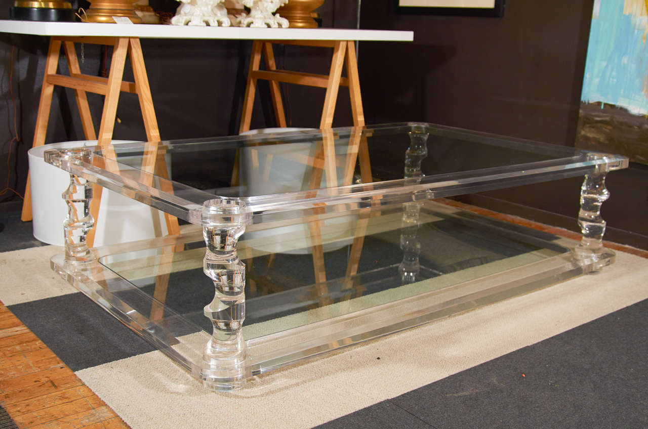 A large vintage Springer style coffee table with a glass top and lower tier framed by thick, clear Lucite with sculptural Lucite legs. It is in good vintage condition with age appropriate wear; some scratches

Reduced from: $22500
