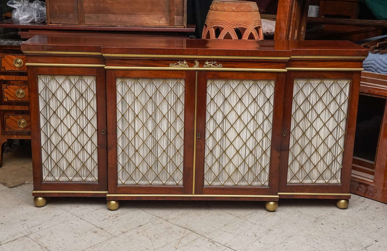 This cabinet made in England circa 1820 is of choice mahogany. Originally designed as a side cabinet for books and the display of select fancy goods. The cabinet has had its center interior reconfigured for cutlery and storage. New drawers have been