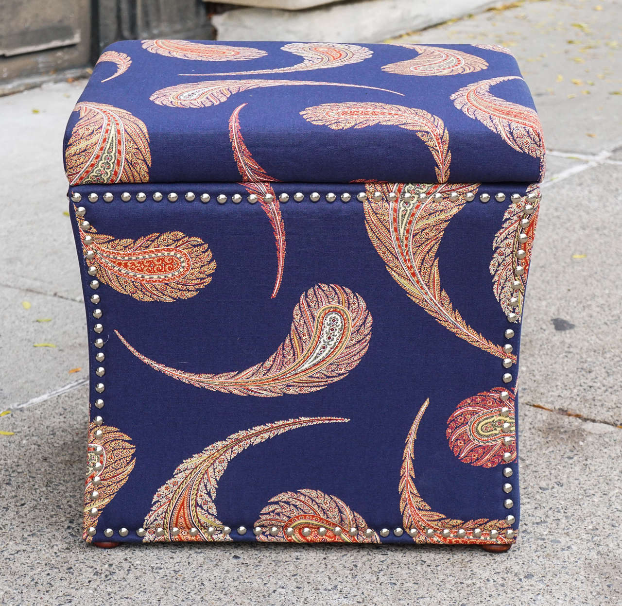 This nice pair of storage ottomans or book benches are made of upholstered wood with small bun feet in wood.  Completely covered in a modified paisley style woven cotton and further decorated with nickle plated nail head tacks. Light and easy to