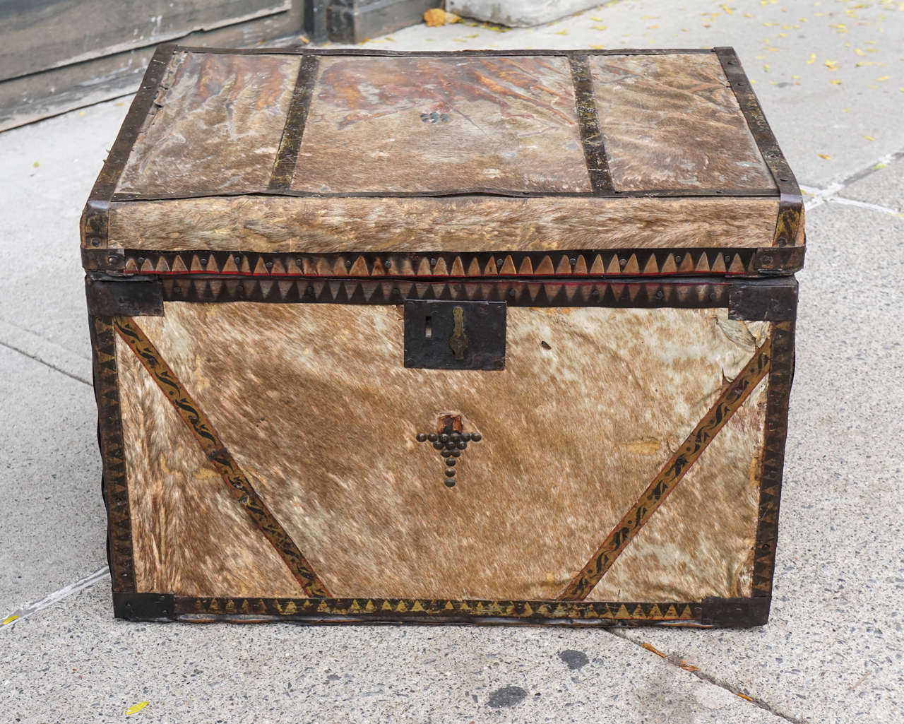 This unusual trunk made in america circa 1870 to 1880 has a western vibe but could have been made on the east coast as a special order. Created from pine which is them covered in pony skin and edged with tole decorated strips of tin   at the edges