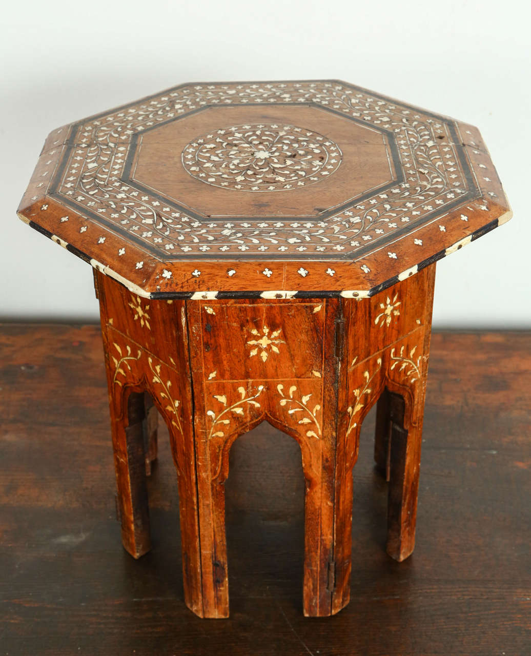 Small bone and ebony inlaid octagonal table, Anglo-India tabouret.
A late 19th century Anglo-Indian rosewood table, the octagonal top with all-over bone inlay featuring an eight-sided central pinwheel medallion, bordered by a scrolling design of