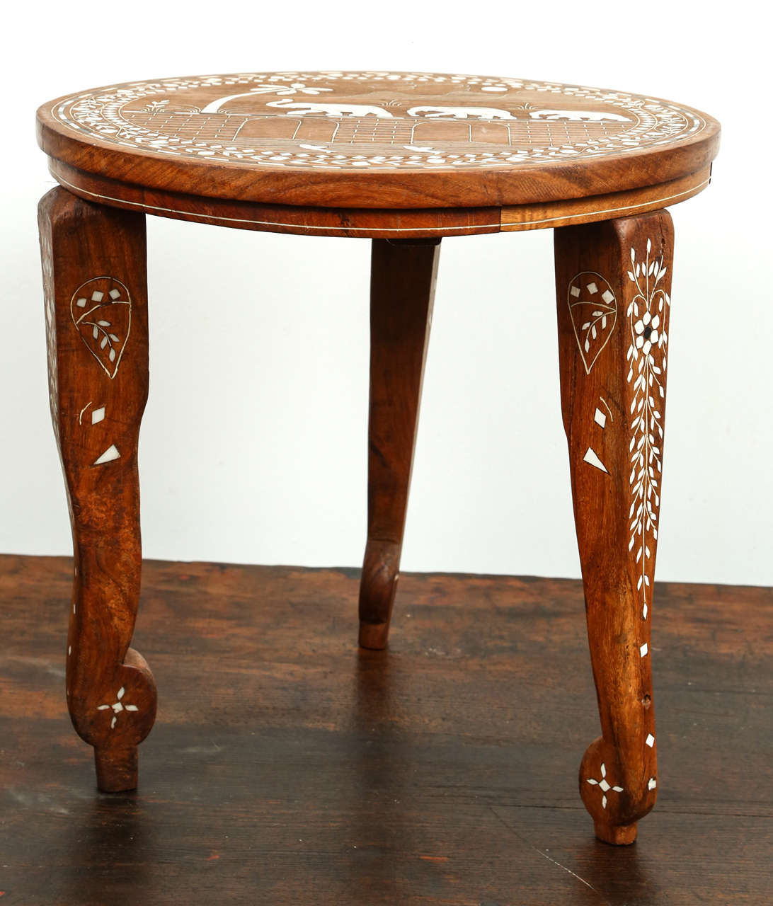 Anglo Indian elegant round wooden side table delicately handcrafted and inlaid with mother-of-pearl. 
Elephants designs on top, bone inlay in Moorish designs and elephant head designs on the three legs.