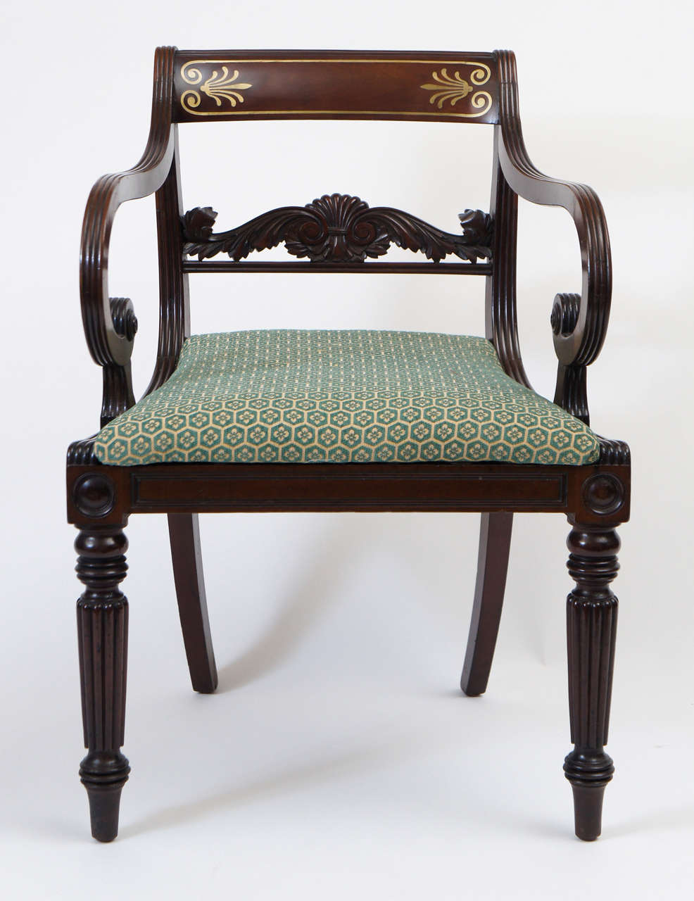 Fine quality circa 1815 late George III English Regency period neoclassical style mahogany armchair having anthemion motif brass inlaid backrest above intricately carved acanthus design horizontal splat, dramatic scrolling arms surmounting roundel