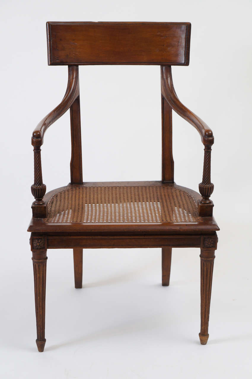 Exquisite French circa 1785 late Louis XVI period and style fauteuil having tall tablet form backrest on chamfered vertical supports continuing into dramatic panel cut splayed rear legs joined by rosette blocks connecting horse-shoe form caned seat