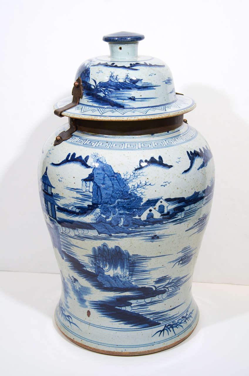 A pair of 19th century Chinese Blue and White covered vases with continuous hand painted scenes showing pagodas and  mountains rising from the sea. 
They have metal mounts for the covers.