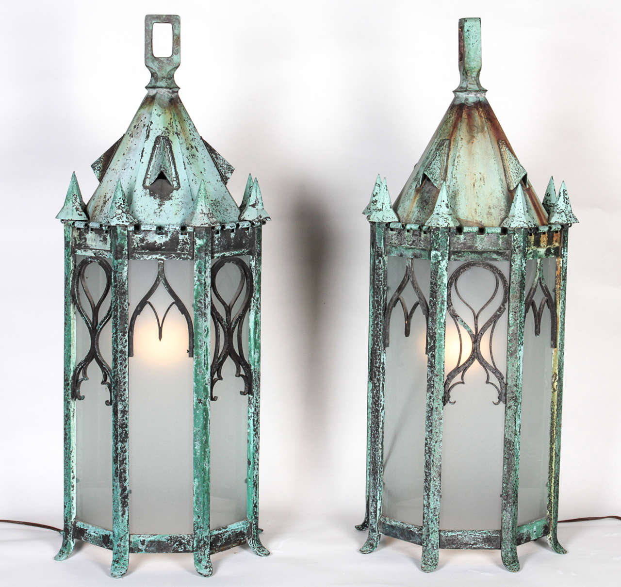 American, early 20th century pair of bronze lamps. Excellent aged green patina. The pair has been rewired and newly glazed. They have a fabulous patina and remarkable workmanship. Can be used as hanging lamps or table lamps. Incredibly unique and