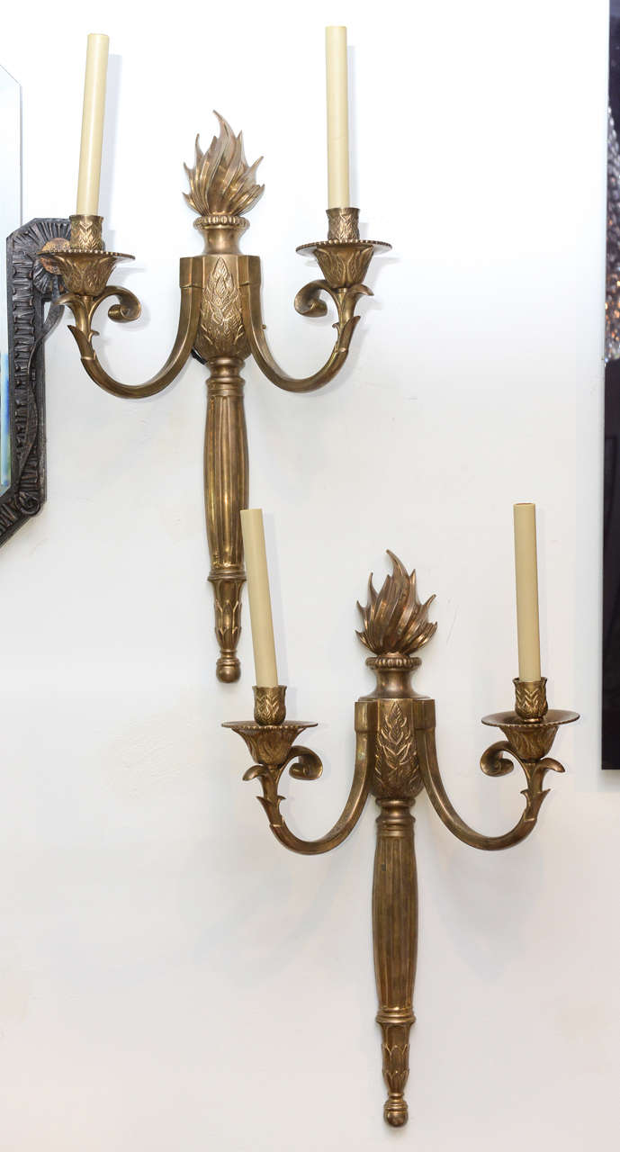 The flame finial above a central section with foliate and fluted columnar stem, with two arms similarly decorated.