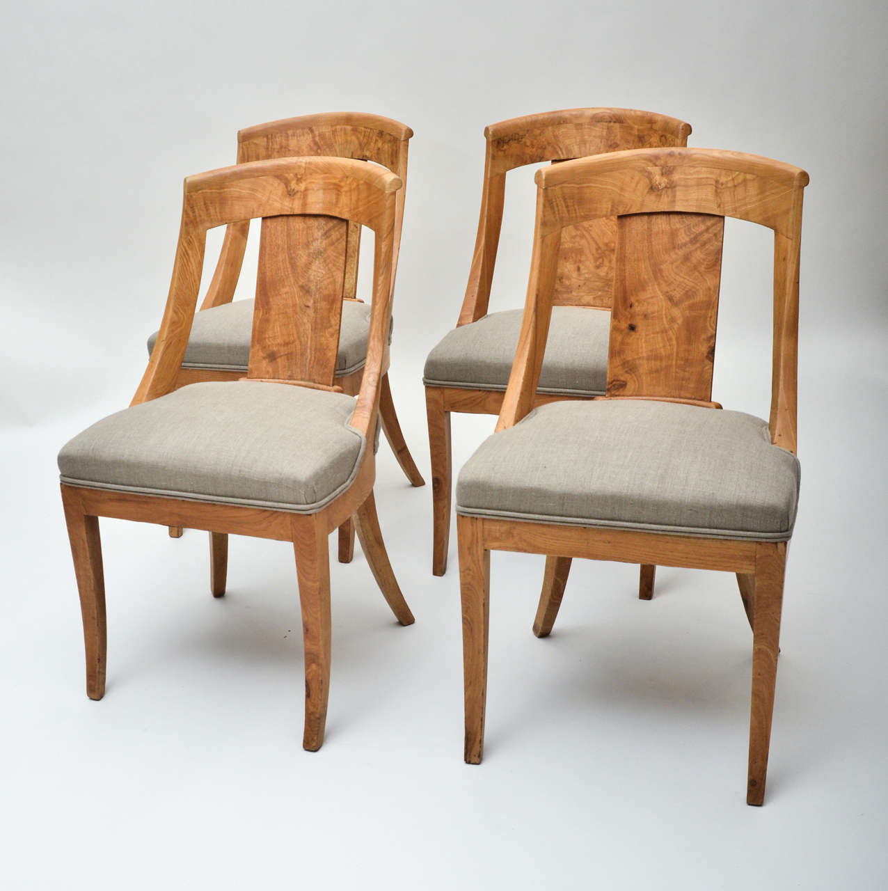 A set of four early 19th century Biedermeier chairs in elmwood, upholstered in cream calico.