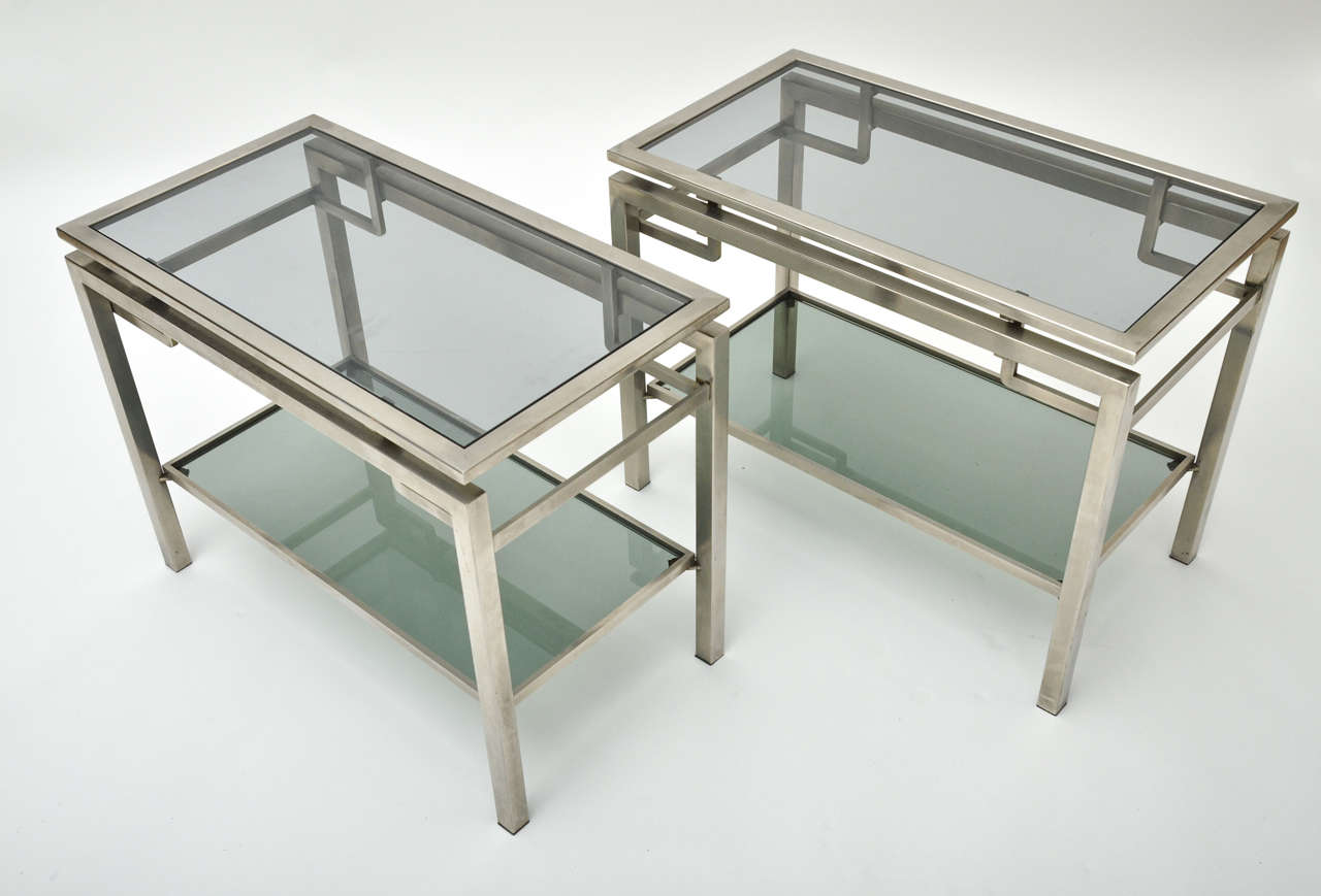 A pair of 1960s French Guy Le Fevre chrome side tables with two tiers in brushed chrome. Matching coffee table available.
