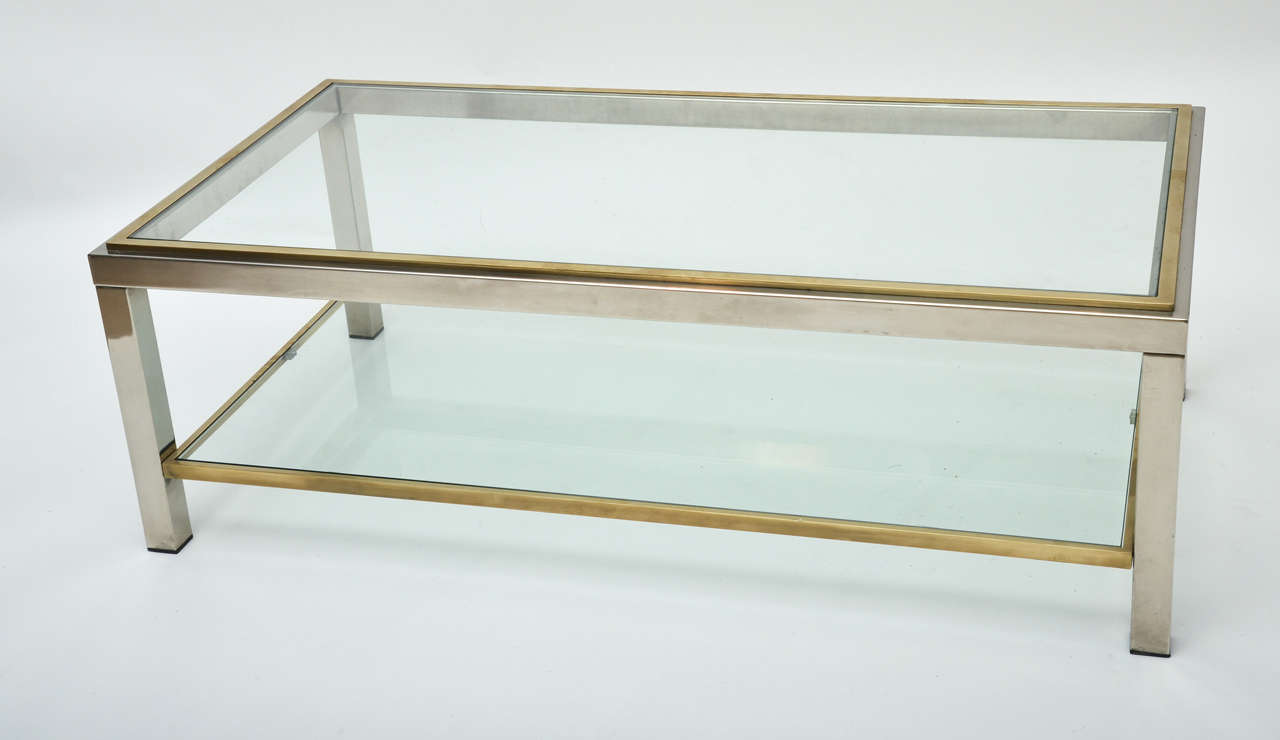 A brass and chrome glass coffee table with two-tier, chrome with brass trim.