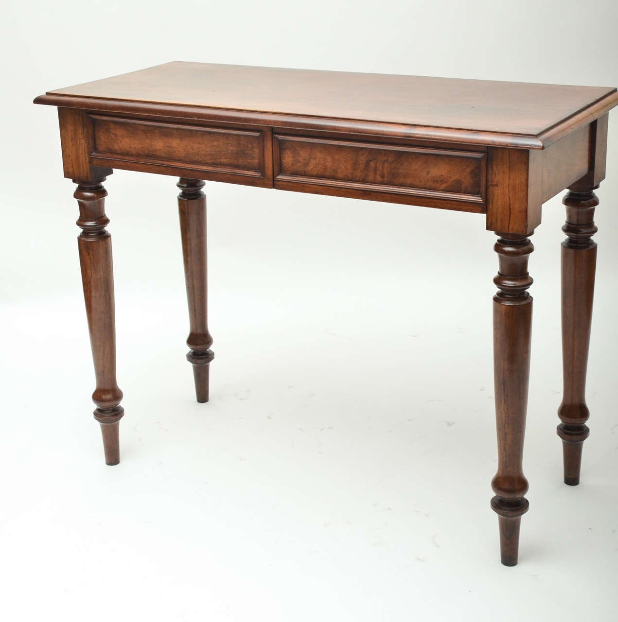 A 19th century English mahogany serving table with two fitted frieze drawers, and turned legs.