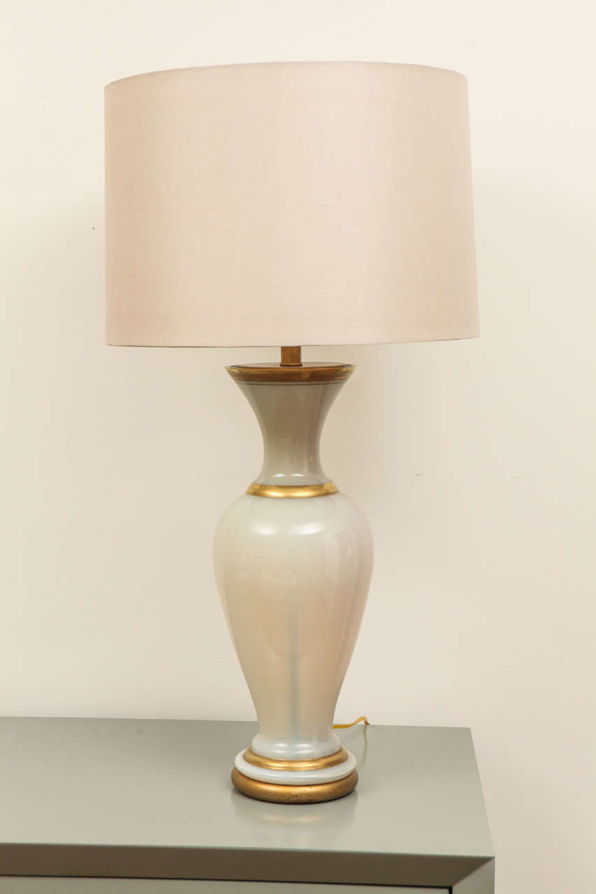 Unattributed semi-translucent glass table lamp with gold bands on a giltwood base