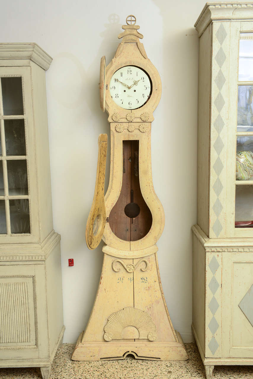 Late 18th century extraordinary collectible Mora clock, signed AAS, in original paint with intricate fan carving motif just below the clock face and just above the clock base;  additionally, the sides of the clock are beautifully carved.  Just below