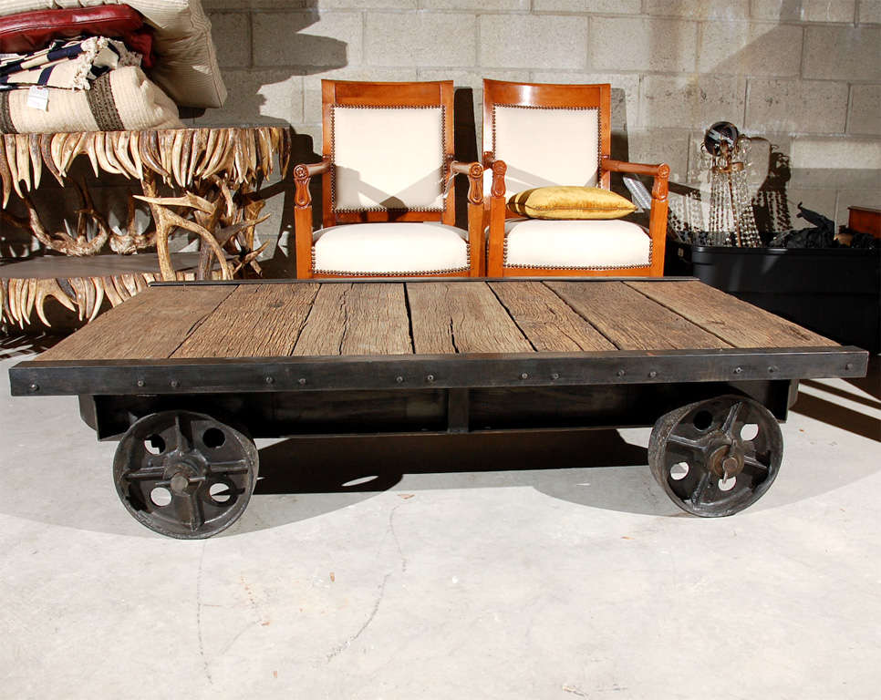 The industrial style wood plank top is enclosed on each side with metal and rests on four pierced metal wheels.