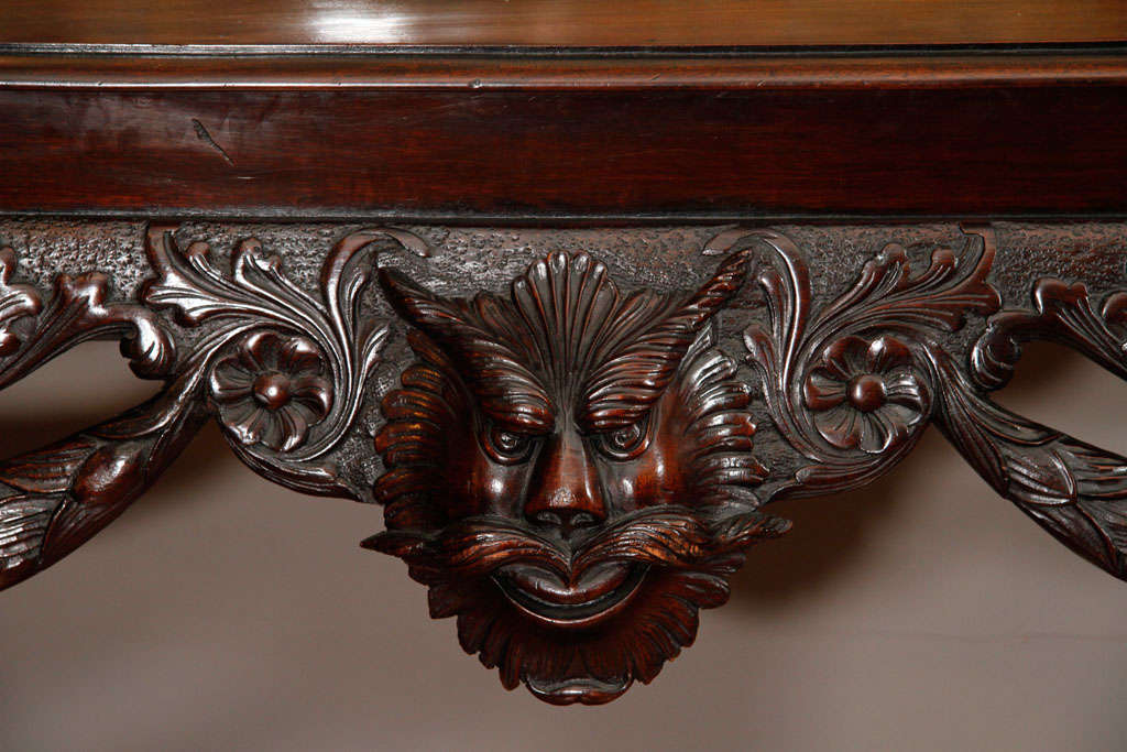 19th century Irish mahogany mask table with foliate swags, cabriole legs terminating in paw feet.