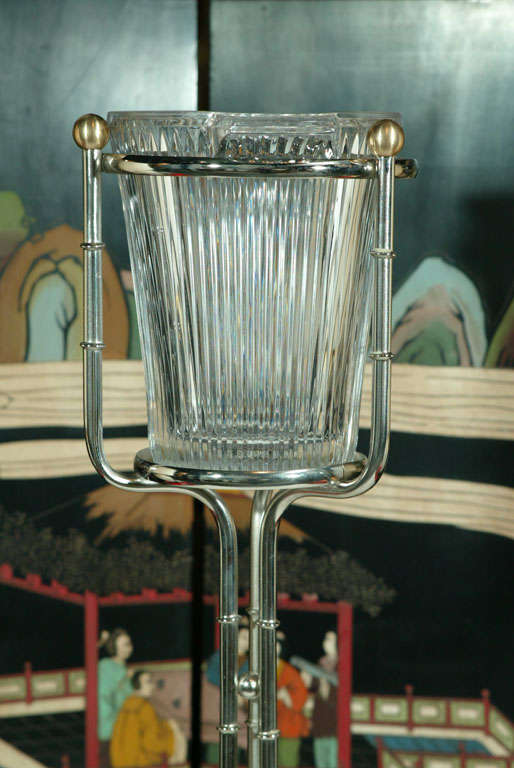 A polished nickel stylized Bamboo stand with brass finials with a heavy fluted crystal champagne cooler.