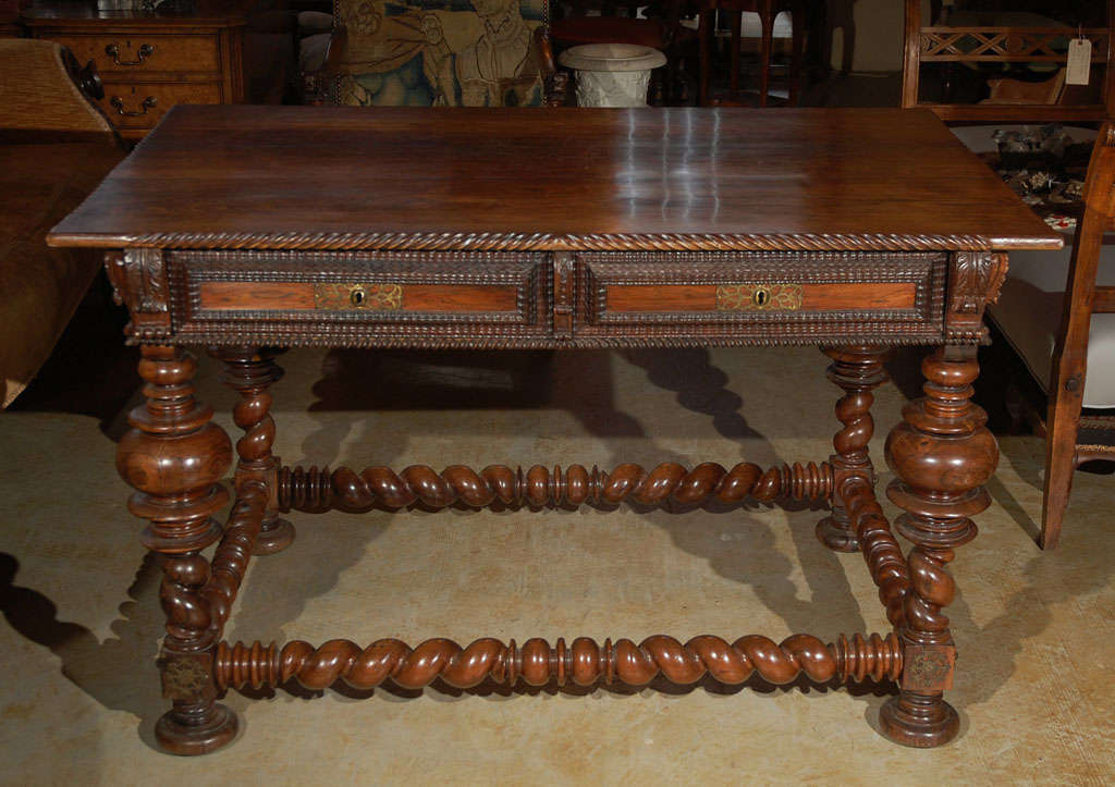 Hand-carved two-drawer  walnut Mesa table with brass studs and turned stretchers.