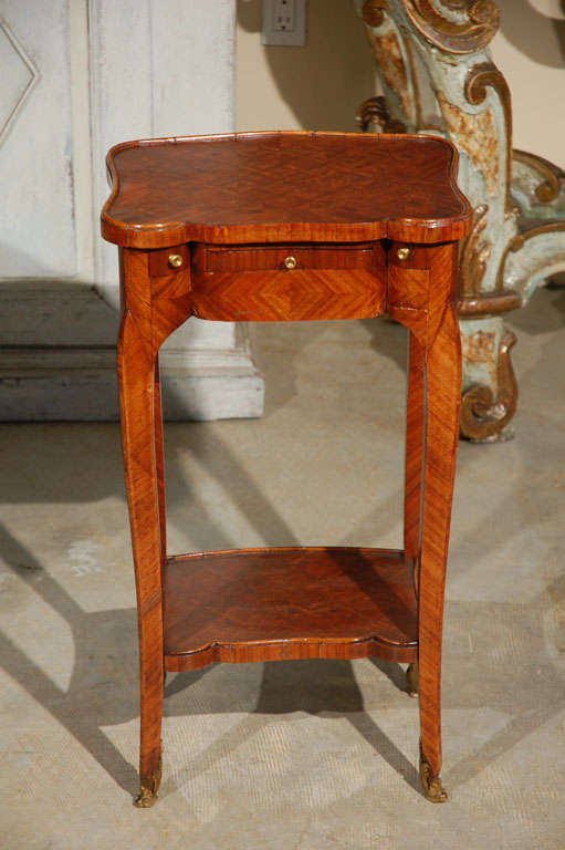 Beautifully proportioned, French side table with a tilt top writing surface, two narrow drawers for pens and/or game chips and ormolu feet.