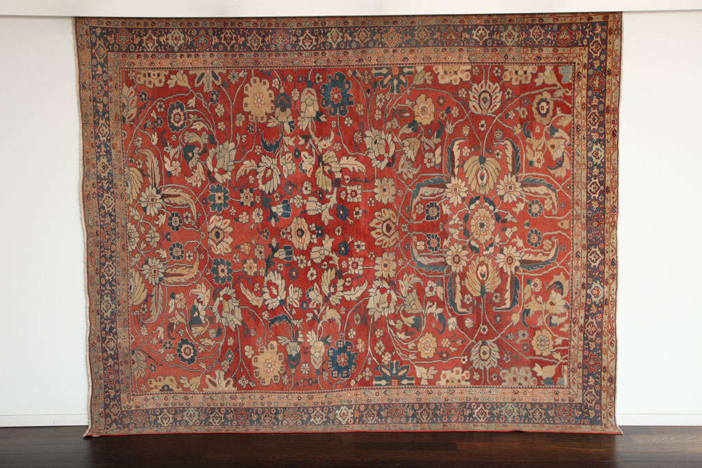 This Persian Sultanabad carpet circa 1870 consists of handspun wool and vegetable dyes. The pile is hand-knotted, and the carpet is in excellent antique condition. Its rich gold, blue and red tones have naturally subdued with age, resulting in a