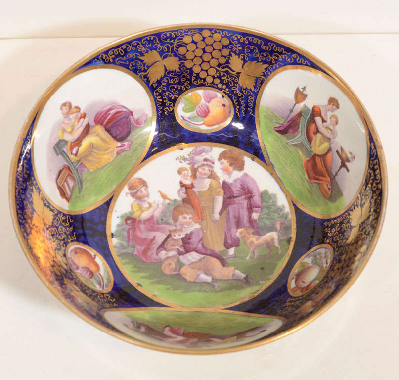 We are pleased to offer this cobalt blue Newhall porcelain bowl was made by Adam Buck. It is decorated with charming scenes of children at play. The artist Adam Buck (1759–1833) was a neoclassical portraitist and painter. The vibrant colors of the