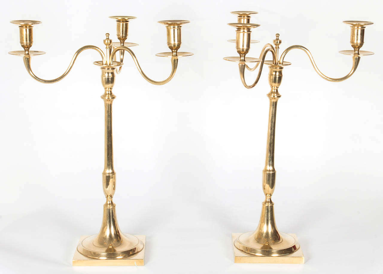 A pair of Swedish brass candelabra from Skultuna, Circa 1860s, each with three scrolled arms set into a removable center bobeche, on a circular spreading stem ending with a square base. Can be used as candlesticks.

This is a larger scale than