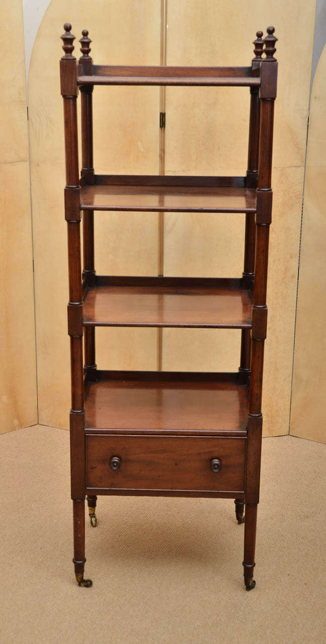 Early 19th century étagère with four tiers, one with a drawer, turned urn finials and supports, original wooden knobs.