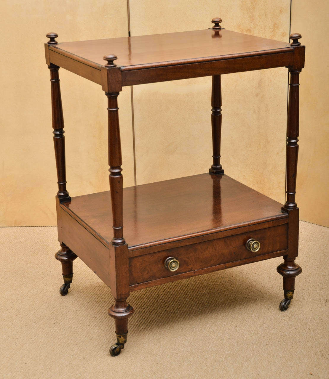 An early 19th Century two-tier side table with drawer and original brass casters.