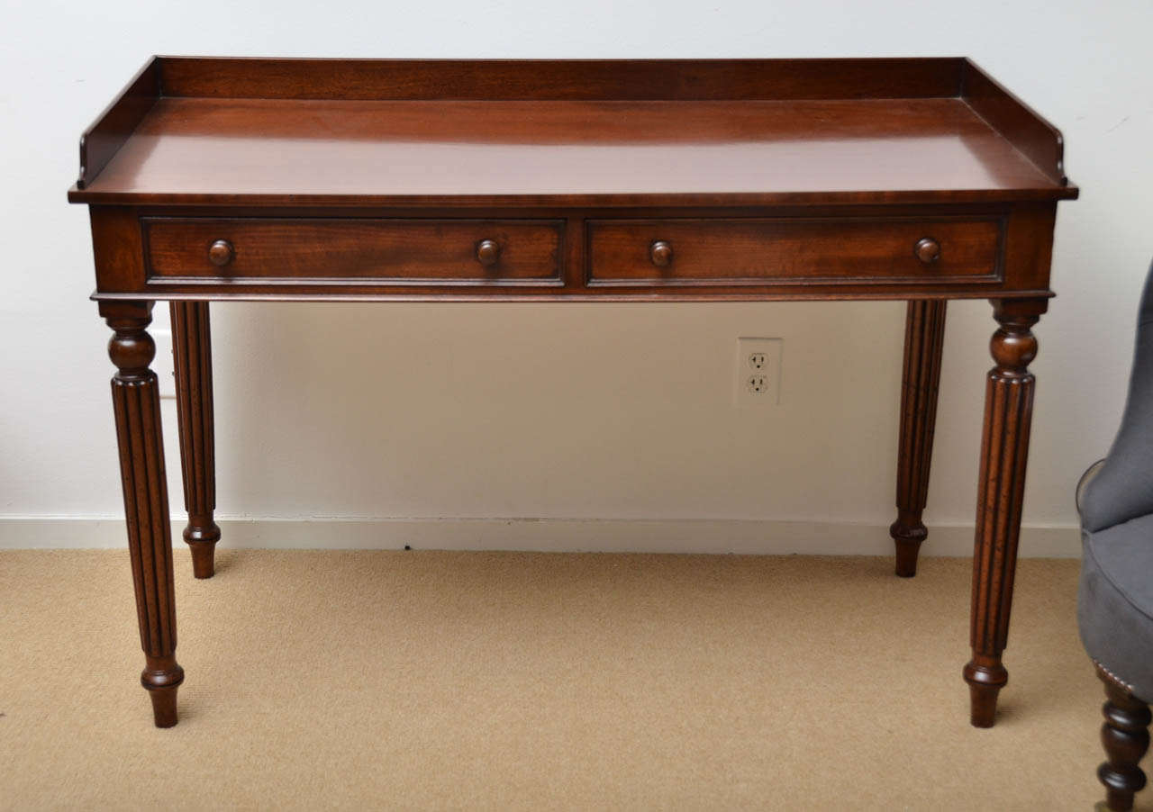 A 19th century writing table with gallery top, one drawer and turned legs.