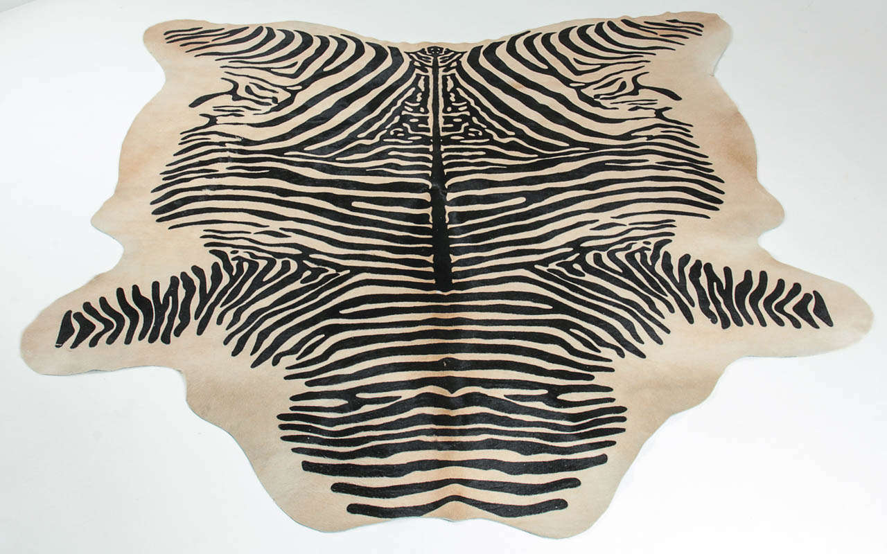 Premium Brazilian cowhide with a black striped stenciled zebra on a light brown/beige hair on hide cowhide.  Beautiful on its own or layered with another rug. This hair on hide is a natural by product of the food industry. The measurements below are