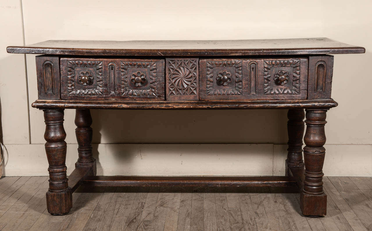 Late 17th or early 18th century walnut library, sofa or console table with two deep with knob pulls drawers. Richly carved and detailed on all sides.