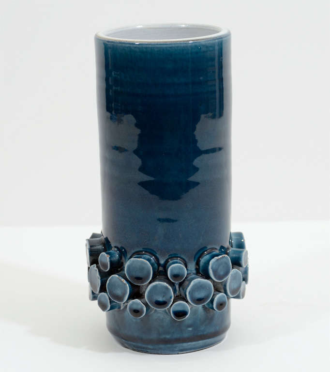 A vintage deep teal blue op-art ceramic vase with white interior by Hans Welling for Ceramano. The piece has a band of circular "knob" form details around the bottom and is signed and numbered on the base.